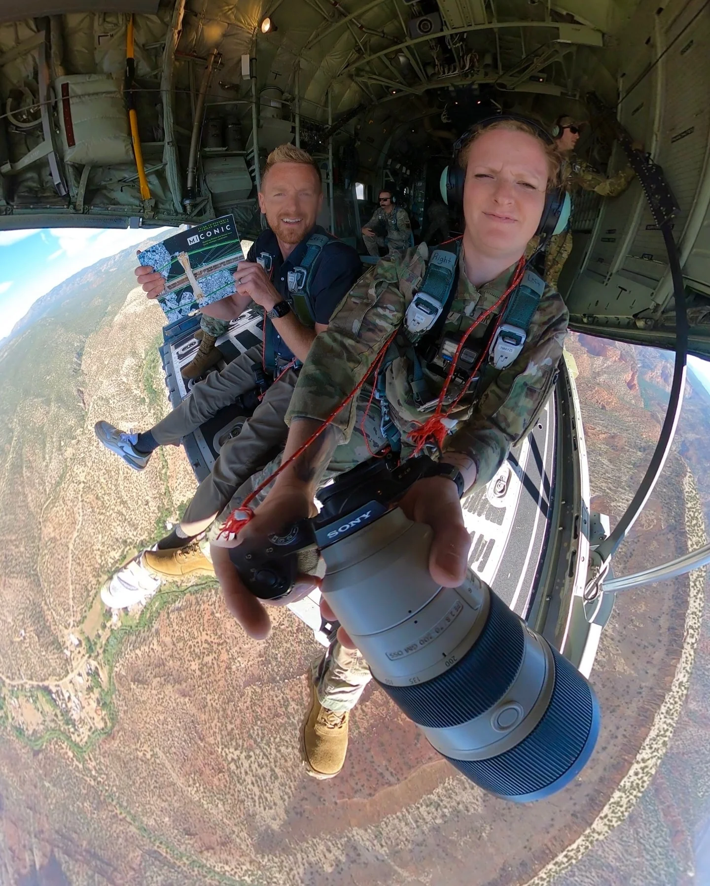 A fish-eye view of skydivers holding a copy of their book before a jump